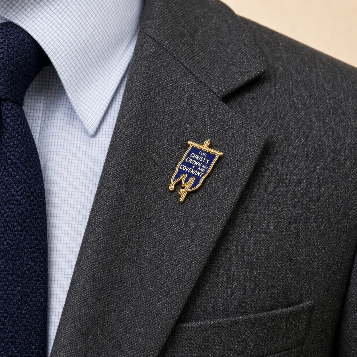 Covenanter Blue Banner lapel pin worn on the gray blazer
