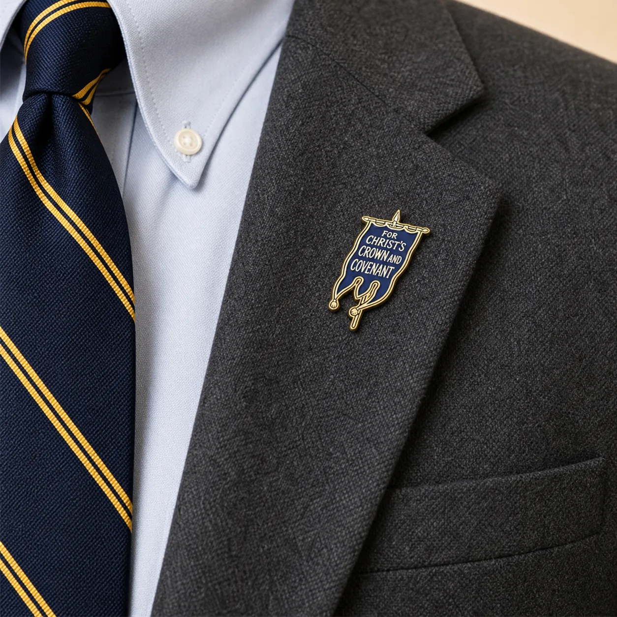 Covenanter Blue Banner lapel pin worn on the gray blazer
